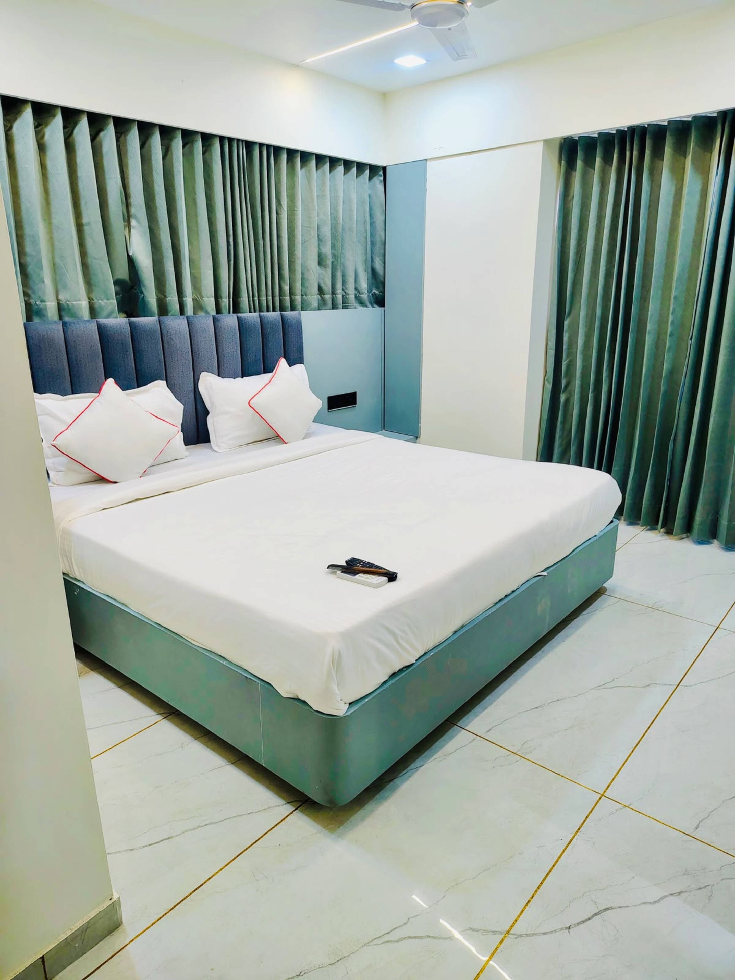 A modern bedroom with a large bed, a headboard with vertical slats, and a ceiling fan.