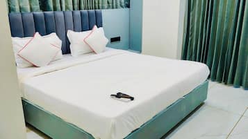 A modern bedroom with a large bed, a headboard with vertical slats, and a ceiling fan.