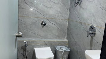 Kylpyhuone, jossa on wc, bidee ja pesuallas, ja kaikki nämä ovat marmoriseinää vasten.