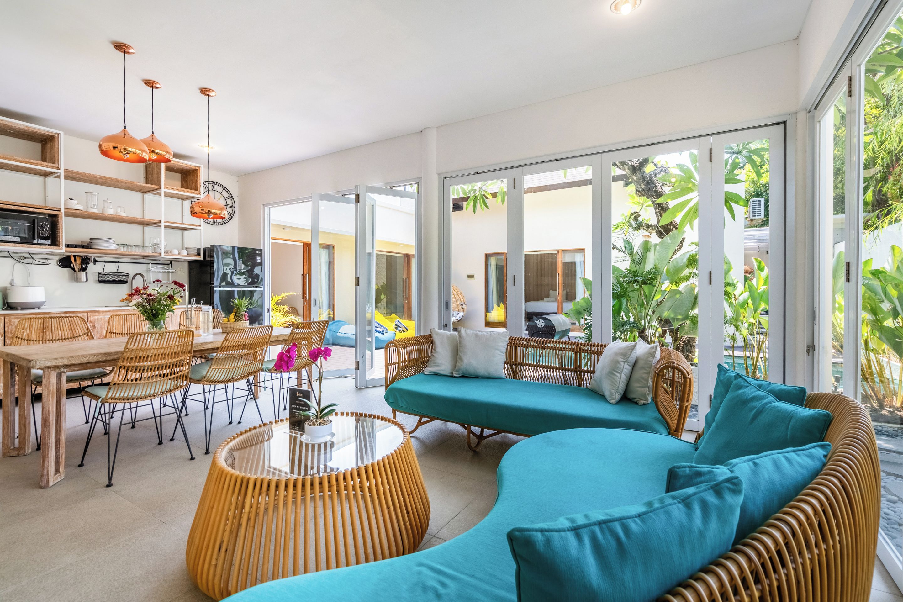 Een moderne woonkamer met een gebogen bank, een eethoek en een keuken.