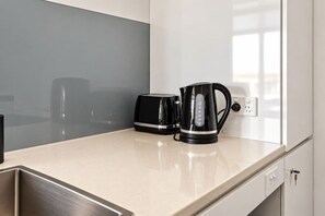 A kitchenette with a toaster, a kettle, and a sink. - Walk to King St & RBWH | Parking (Bowen Hills)