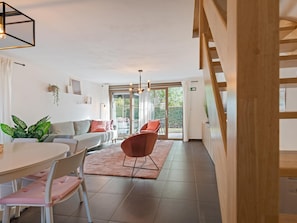 A modern interior with a dining area, a sofa, and a staircase. - Modern holiday home with terrace by the coast (De Panne)