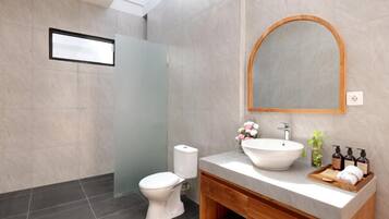 Uma casa de banho moderna com sanita, lavatório e espelho.