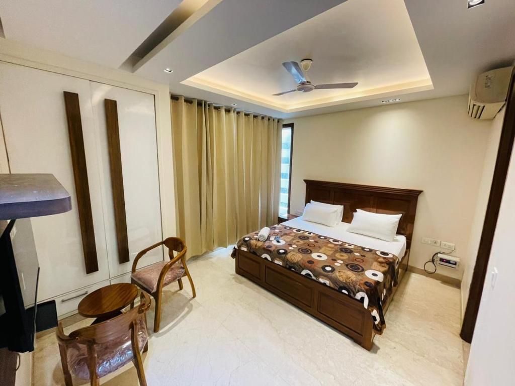 Une chambre d’hôtel avec un lit, un bureau, une chaise et un ventilateur de plafond.