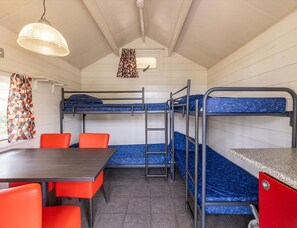 A bunk room with a table, chairs, and a hanging light fixture. - Camping Cabin for 4 in Holland (Reutum)