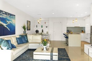 Ein modernes Wohnzimmer mit einer Couch, einem Couchtisch und Kunstwerken an der Wand.