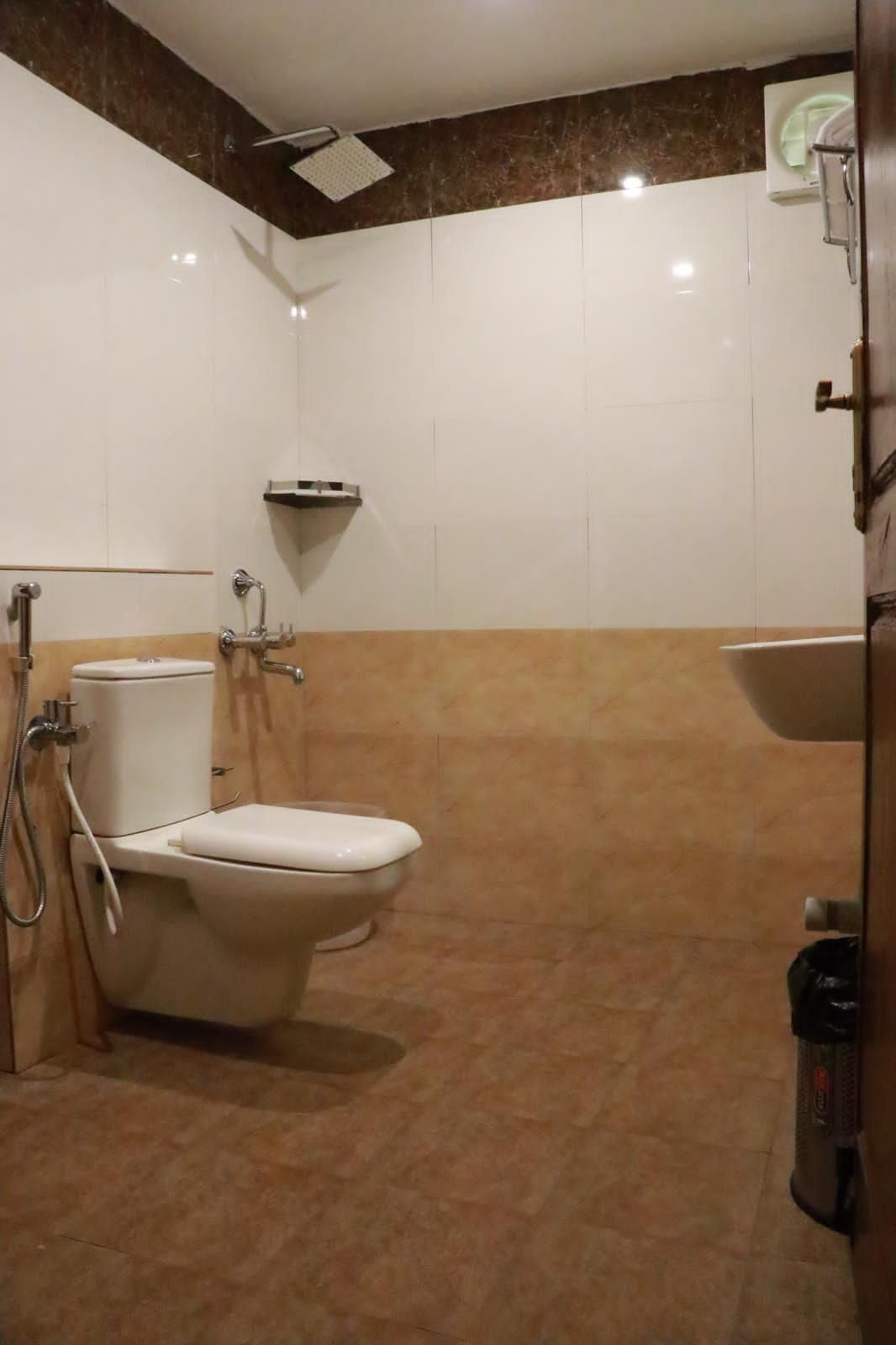 A bathroom with a toilet, shower, and sink.