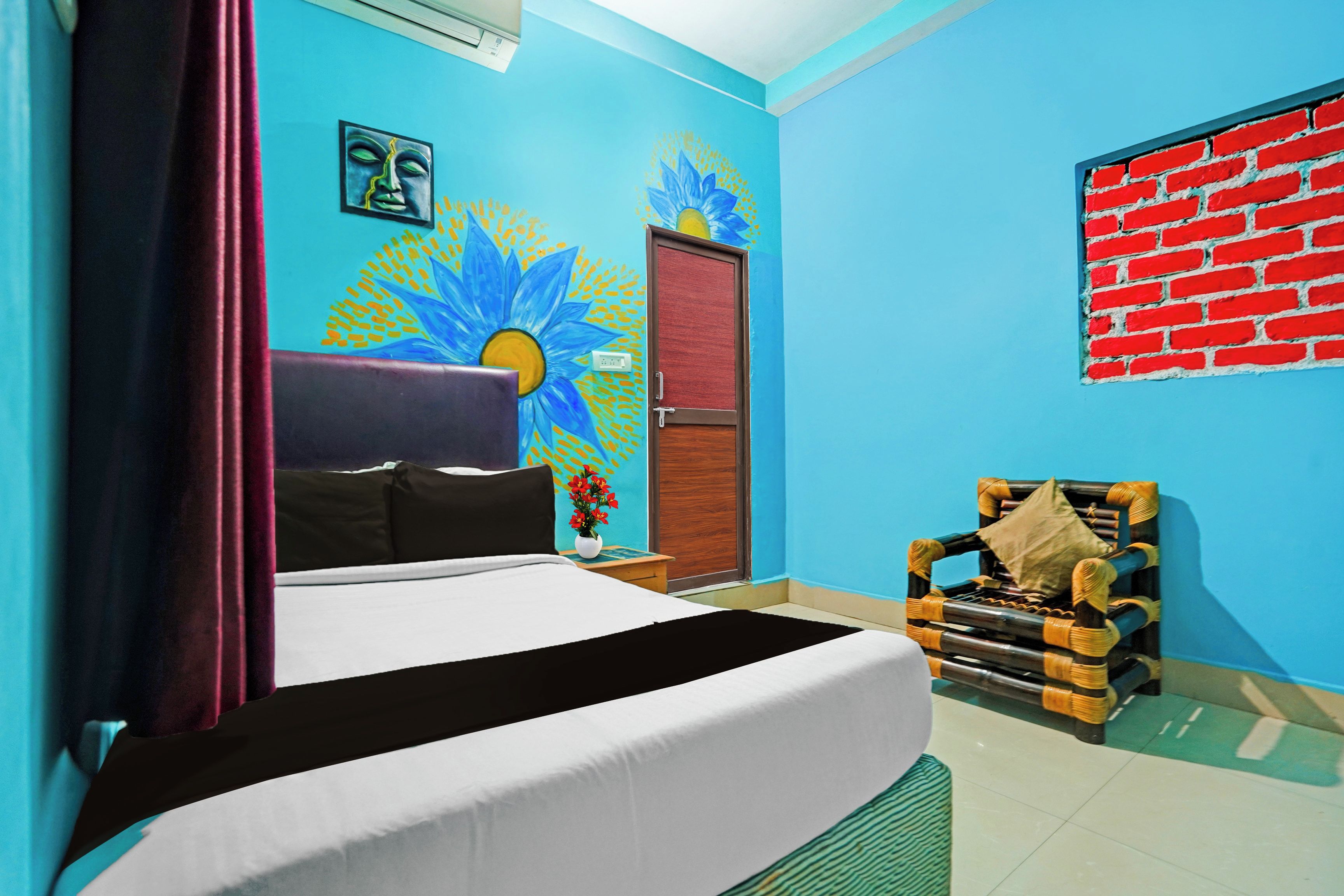 Quarto com cama, cadeira, parede com mural e parede de tijolos vermelhos.