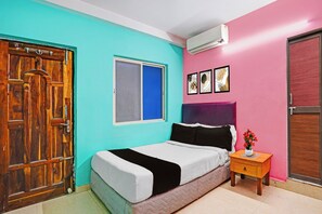 A bedroom with a bed, a nightstand, a window, and a door.