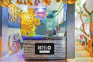 A hotel reception desk with a sign indicating it is OYO-Serviced.