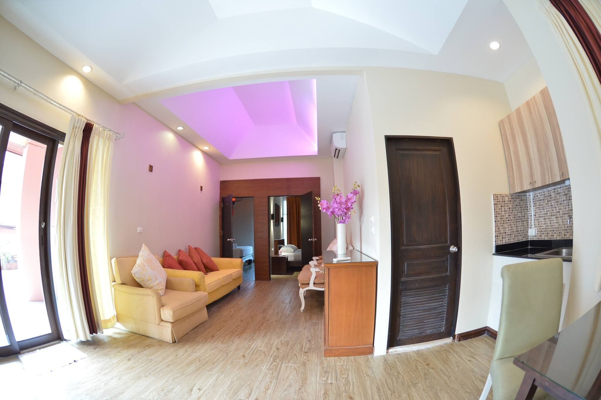 A spacious living area with a sofa, a coffee table, and a door leading to another room.