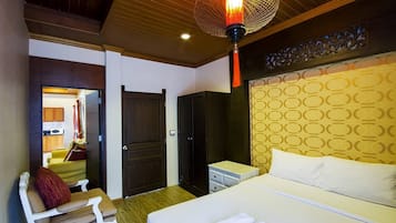 A hotel room with a bed, a desk, a chair, and a wardrobe.