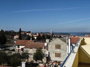 A coastal town with stone buildings, a church tower, and a view of the sea. - Apartments Milena (Murter-Kornati)