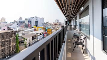 A balcony with a view of a cityscape, including buildings and a clear sky.