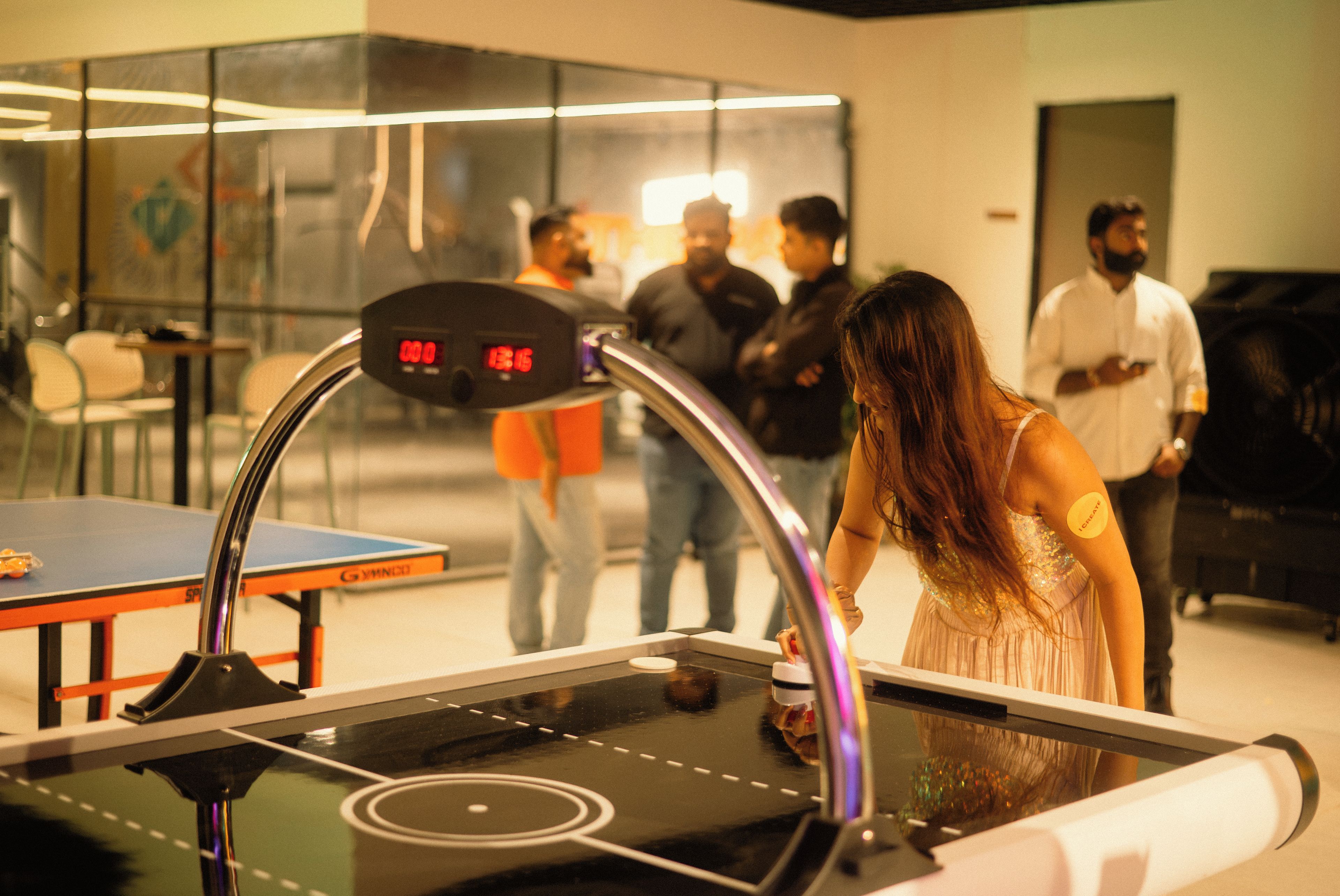 A table tennis table with a digital scoreboard in a room with glass walls.