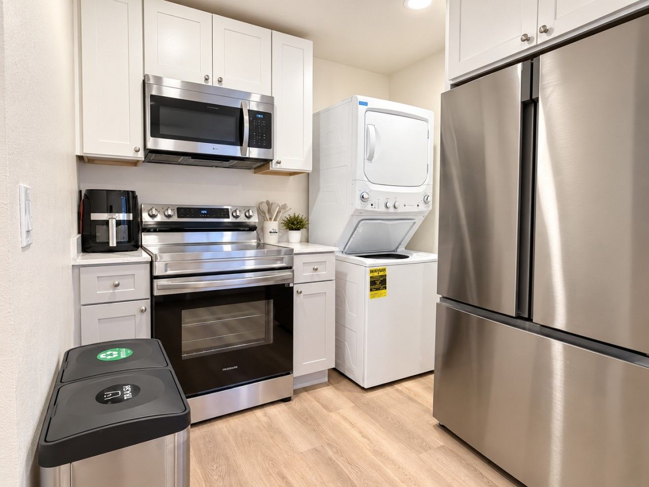 Una cocina moderna con electrodomésticos de acero inoxidable, incluyendo un microondas, horno y refrigerador.