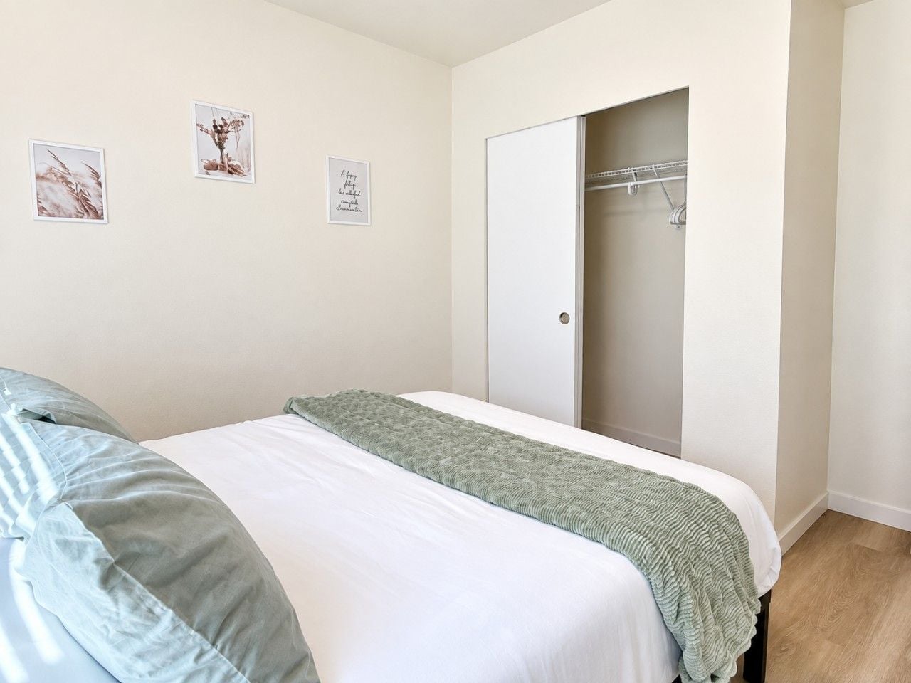 Un dormitorio con dos camas, un armario y una puerta que da a un baño.