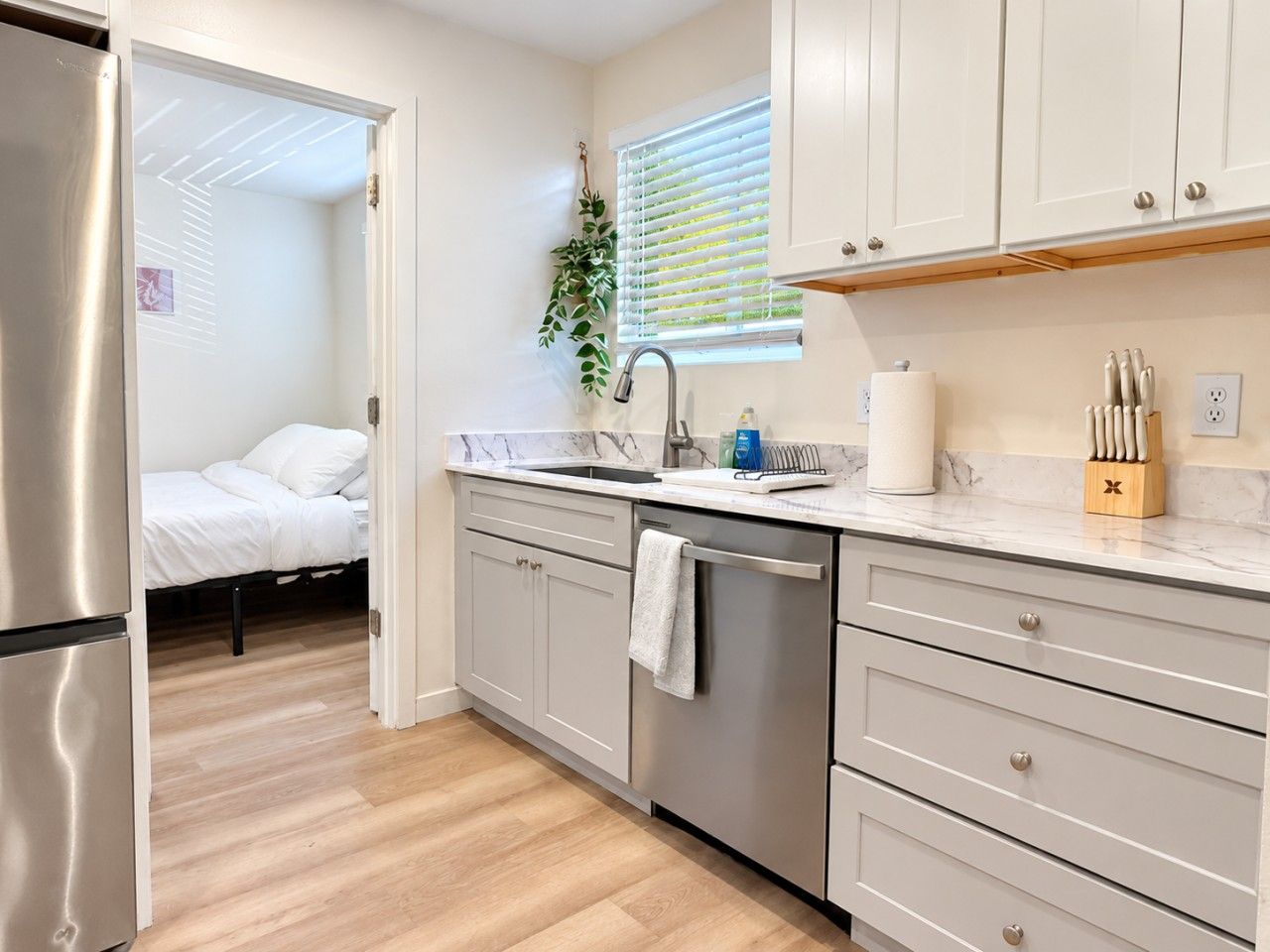 A modern kitchen with a dishwasher, a sink, and a countertop with a knife block.