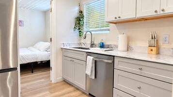 A modern kitchen with a dishwasher, a sink, and a countertop with a knife block.