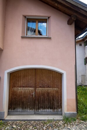 A building with a large wooden door and a small window above it. - Porta Neff Appartement/Fewo, Bad, WC, 2 Schlafräume by Interhome (Bivio)