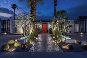 A modern building with a red door, palm trees, and a paved pathway. - The Weekend by AvantStay | 3 Suites • Boutique Stay for 12, Private Patios, Pool (Palm Springs)