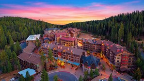 Ein Resort mit mehreren Gebäuden, einem zentralen Innenhof und bewaldeten Hügeln ringsum.