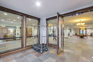 A hotel lobby with a reception desk, a chandelier, and a tiled floor. - Gondola to Skiing! Steamboat Condo w/ Hot Tubs (Steamboat Springs)