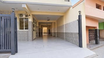 A building with a covered walkway leading to a gated entrance.