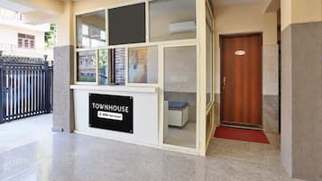 A townhouse with a glass front, a sign indicating it is serviced by a specific company, and a door labeled 'OFFICE'.