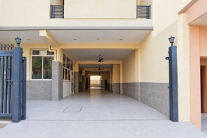 Entrada de un edificio con un camino de entrada porticado, un corredor cubierto y un ventilador de techo.