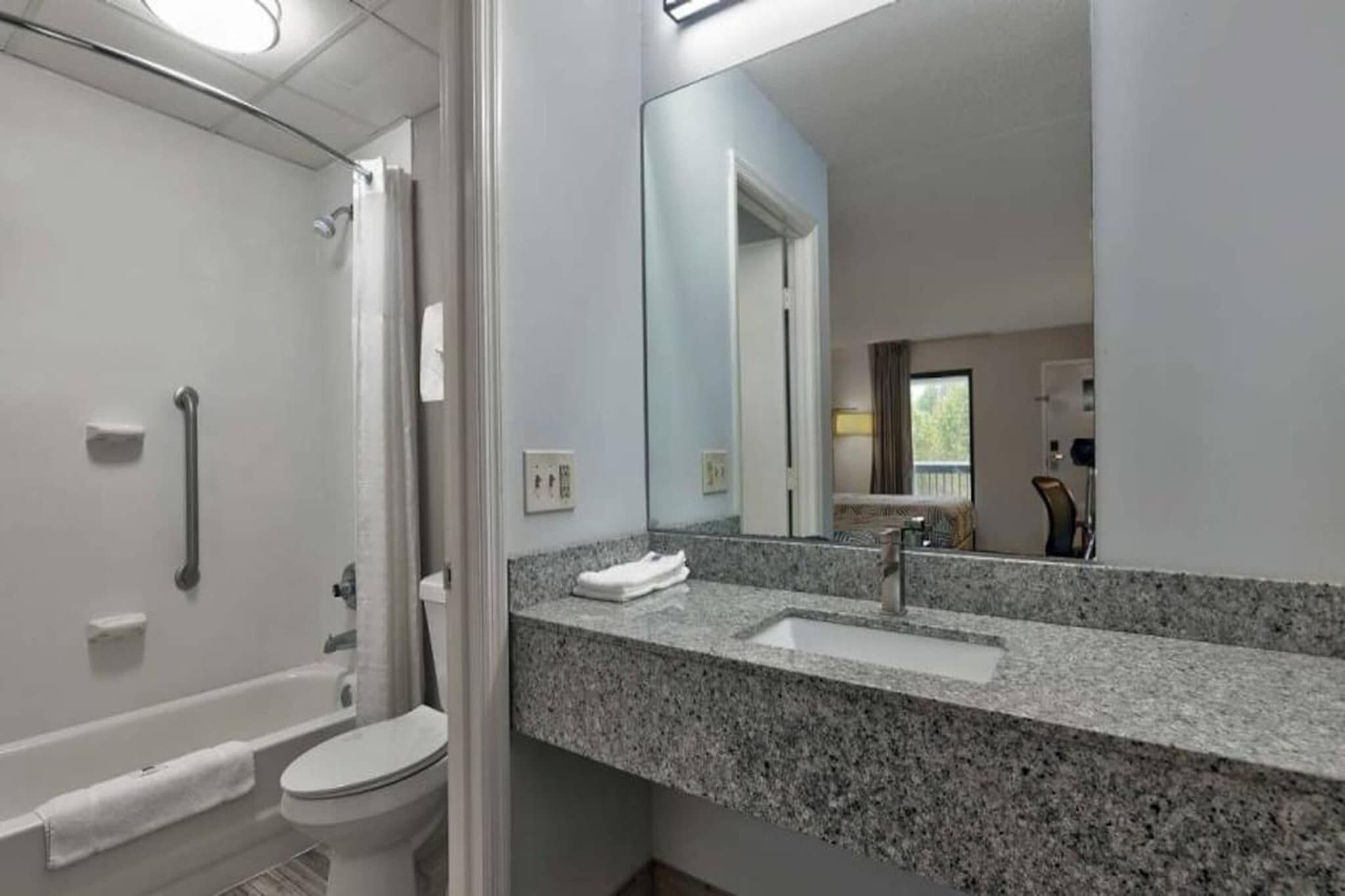 A modern bathroom with a shower, toilet, and sink.