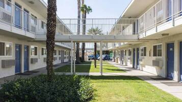 A multi-story motel with a central courtyard, balconies, and a covered walkway.