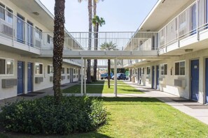 A multi-story motel with a central courtyard, balconies, and a covered walkway.