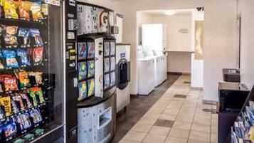 A vending machine with snacks and a water dispenser in a hallway.