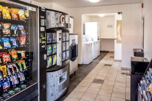 A vending machine with snacks and a water dispenser in a hallway.