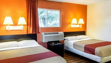 A hotel room with two beds, a window with curtains, wall-mounted lamps, and an air conditioning unit.