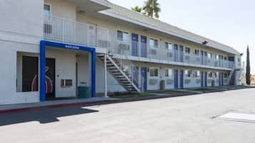 A motel with a 'welcome' sign, a covered outdoor area, and a parking lot.