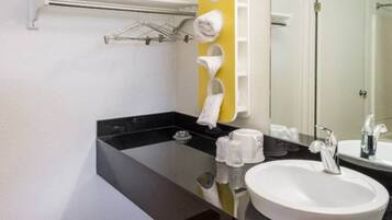 A modern bathroom with a black countertop, a white sink, and a mirror.