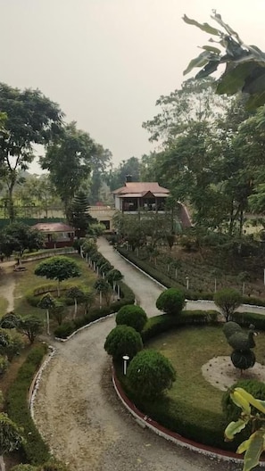 Un jardin aménagé avec un sentier menant à un bâtiment doté d’un toit rouge.