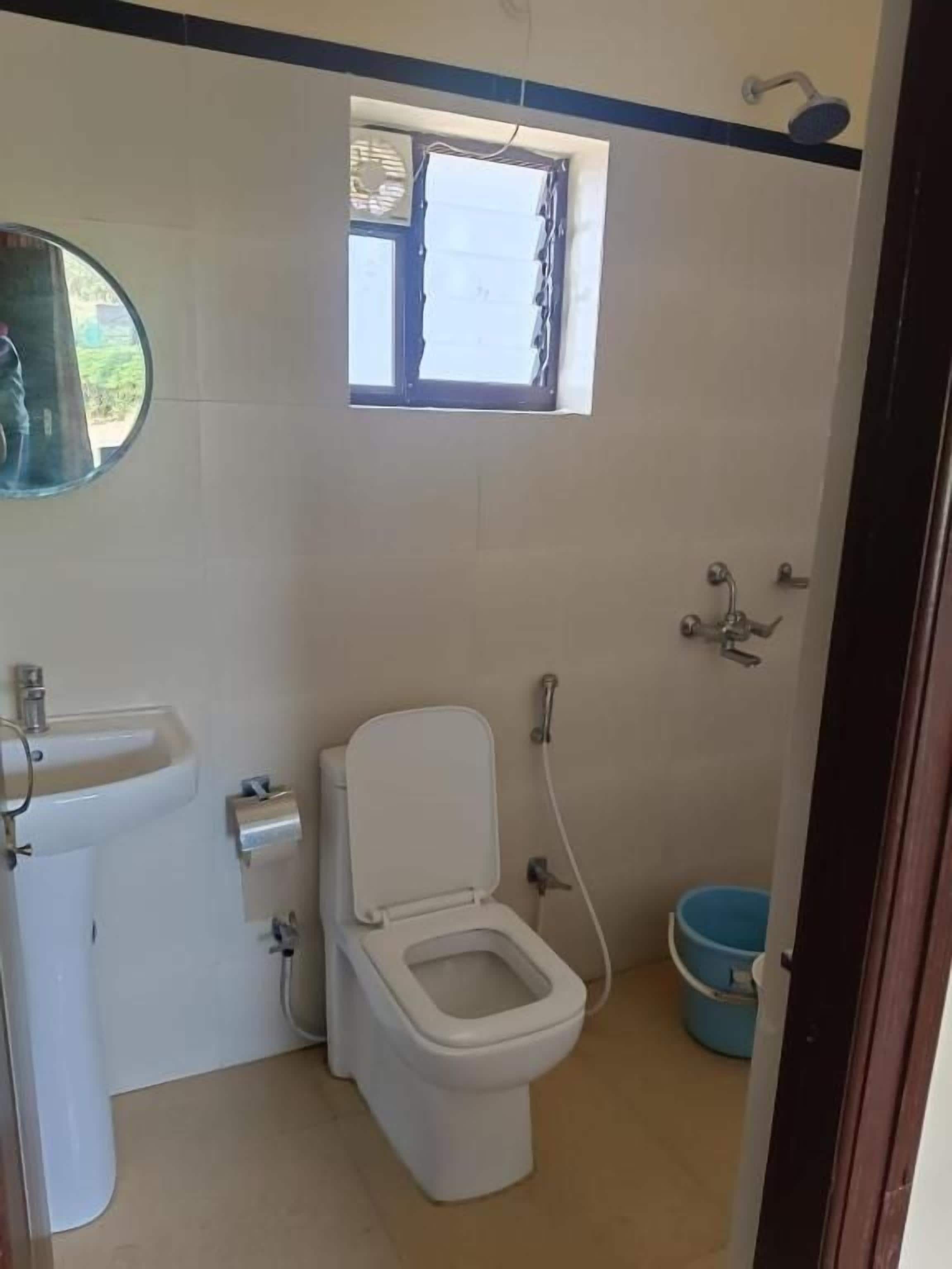Baño pequeño con inodoro, lavamanos y ventana.