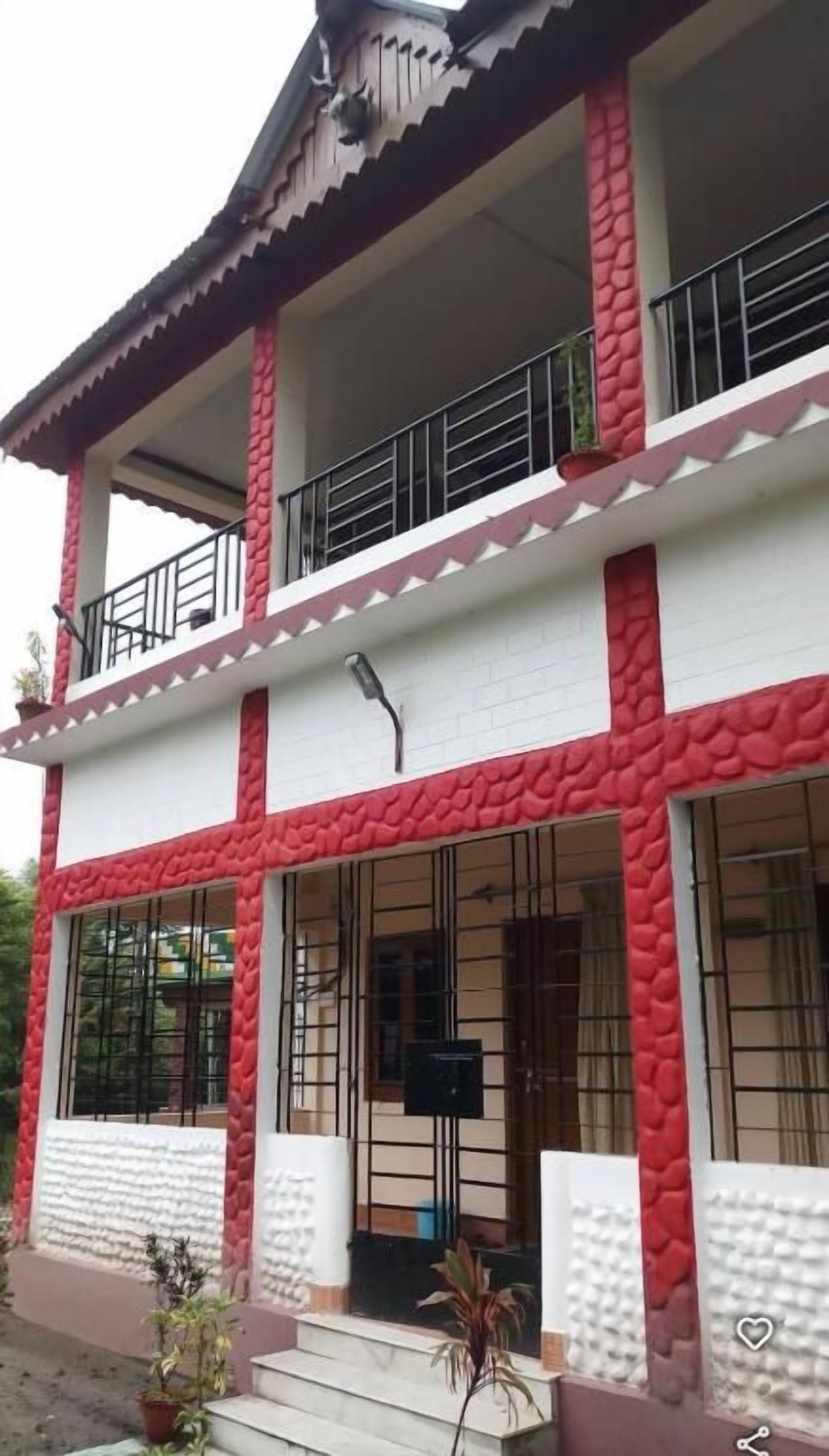 Un edificio de dos pisos con un balcón en el nivel superior.