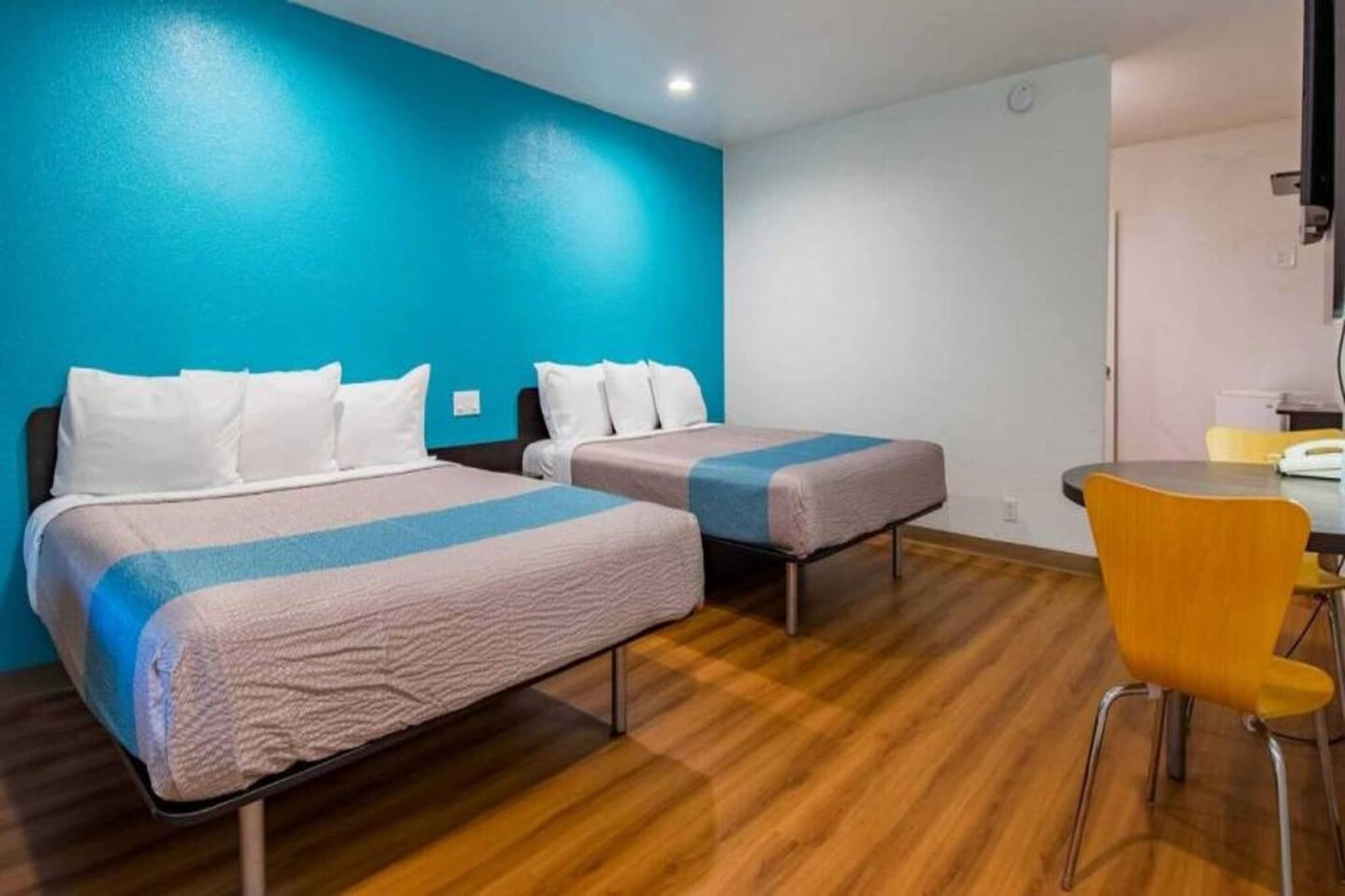 Una habitación de hotel con dos camas, un escritorio y una silla.