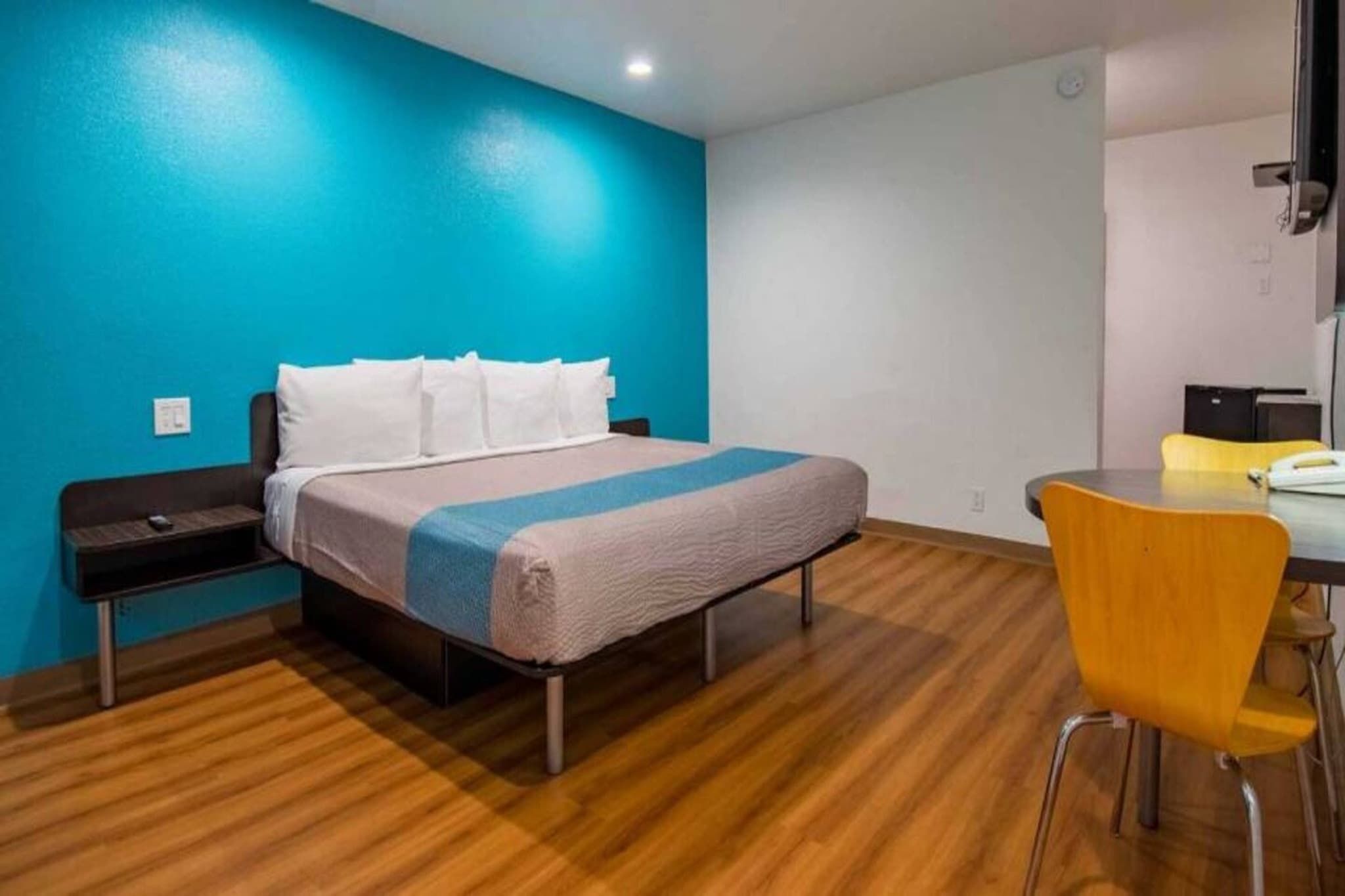 A hotel room with a bed, a desk, and a chair.