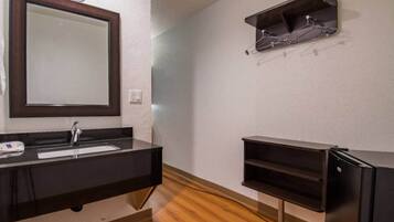 A bathroom with a dark countertop, a mirror, a sink, and a black cabinet.