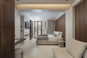 Quarto moderno com cama, sofá, escrivaninha e televisão.
