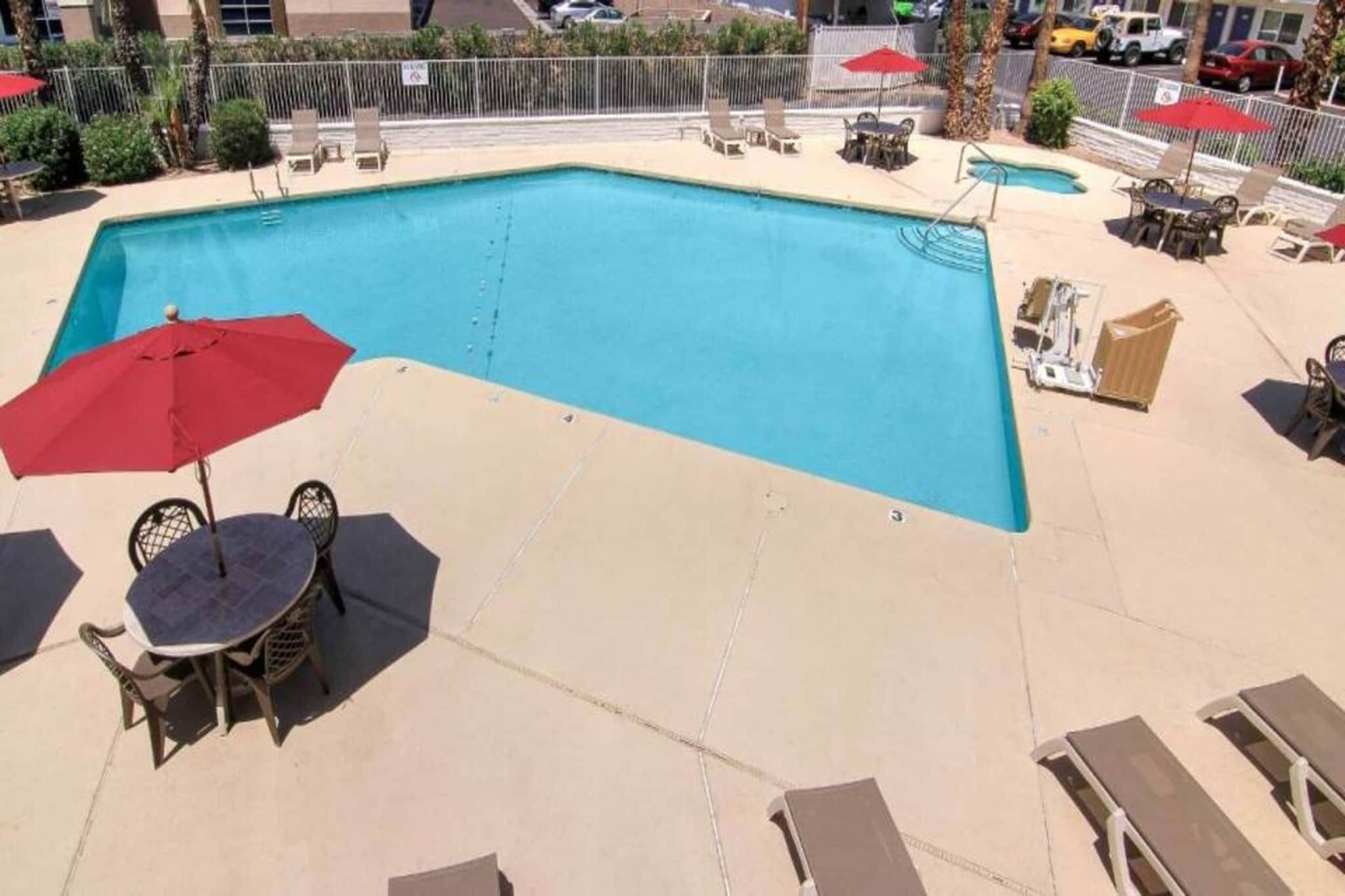 Una piscina con sillas de descanso y sombrillas.