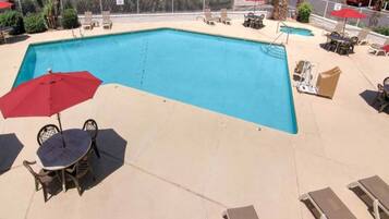 Una piscina con sillas de descanso y sombrillas.