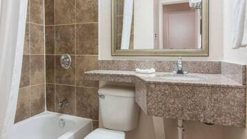 A bathroom with a bathtub, toilet, and sink.