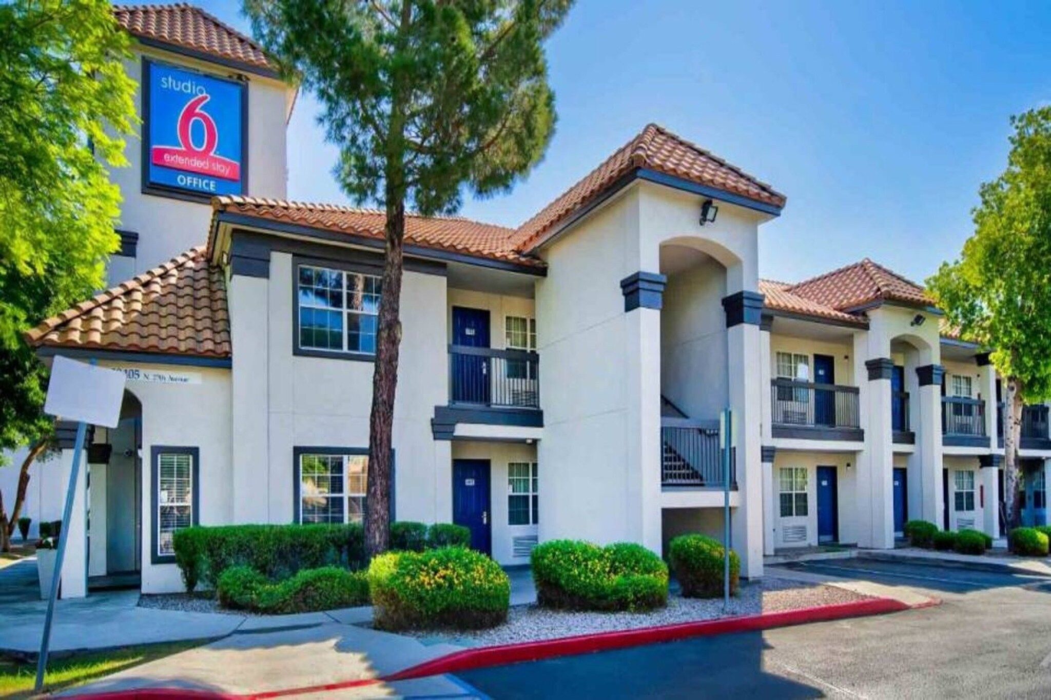 A multi-story motel with a sign indicating 'studio 6 extended stay office' and a visible address.