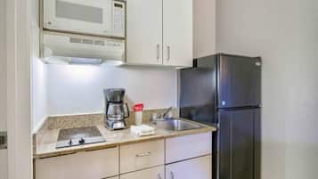 Eine Küche mit Mikrowelle, Kaffeemaschine und Kühlschrank.